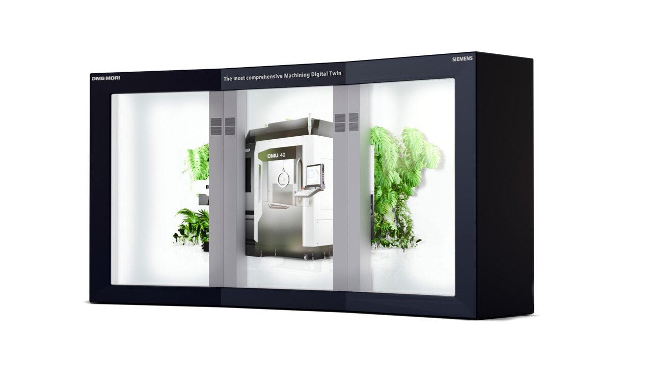 Eine Holobox: Es sieht aus als stünde eine große Industriemaschine hinter Glas, umgeben von Pflanzen, mit der Aufschrift 'DMU 40'.