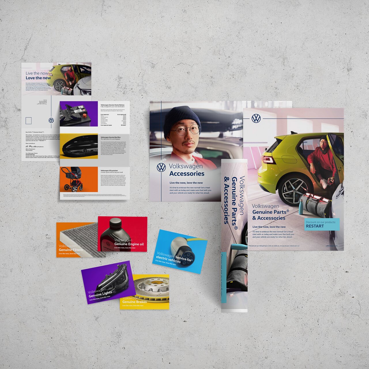 VW-Zubehör- und Ersatzteil-Werbebroschüren mit verschiedenen Bildern und Farben auf Betonuntergrund.