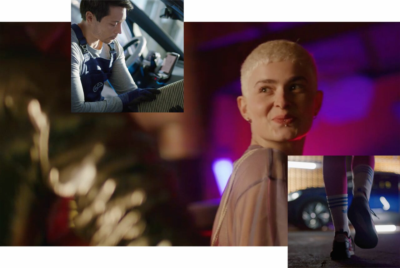 Mann wechselt Innenraumfilter, junge Frau mit Kurzhaarschnitt lächelt, Füße in Sportschuhen vor einem blauen Auto.