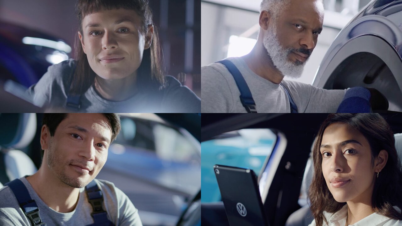 Vier VW-Mitarbeiter:innen in Werkstattumgebung, freundlich und professionell.