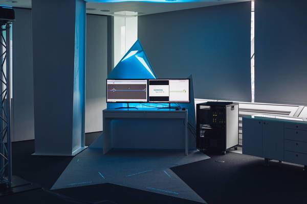 Arbeitsplatz mit zwei Monitoren und Rechner in modernem, futuristisch beleuchtetem Raum.