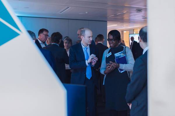 Zwei Personen unterhalten sich in einem vollen Raum.