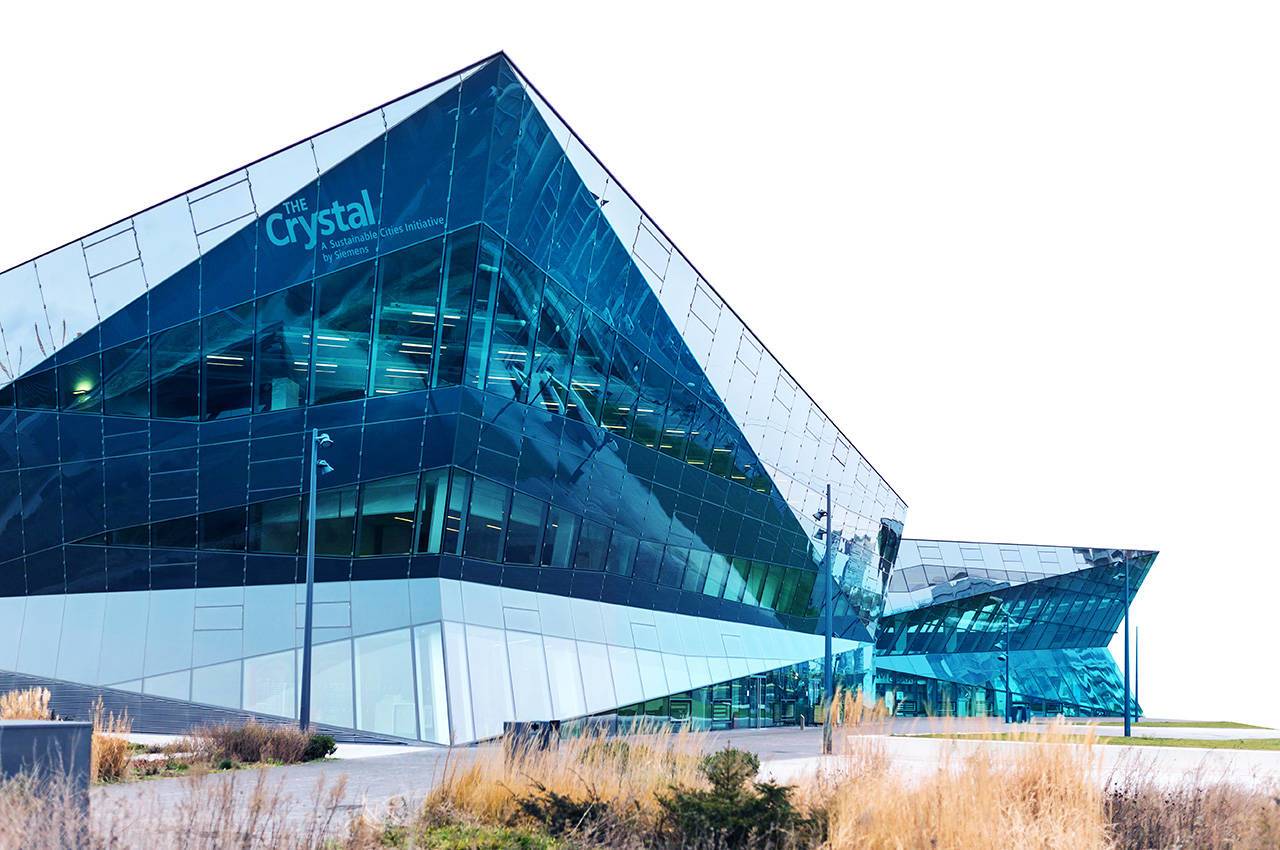 Futuristisch verglastes Gebäude „The Crystal“ mit spiegelnden Fassaden und Schriftzug.