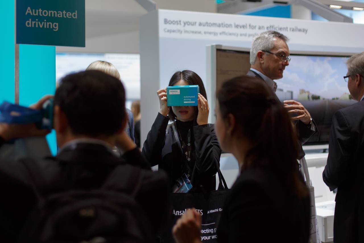 Frau nutzt Siemens-VR-Brille auf Messe, um Virtual-Reality-Inhalt zu erleben.