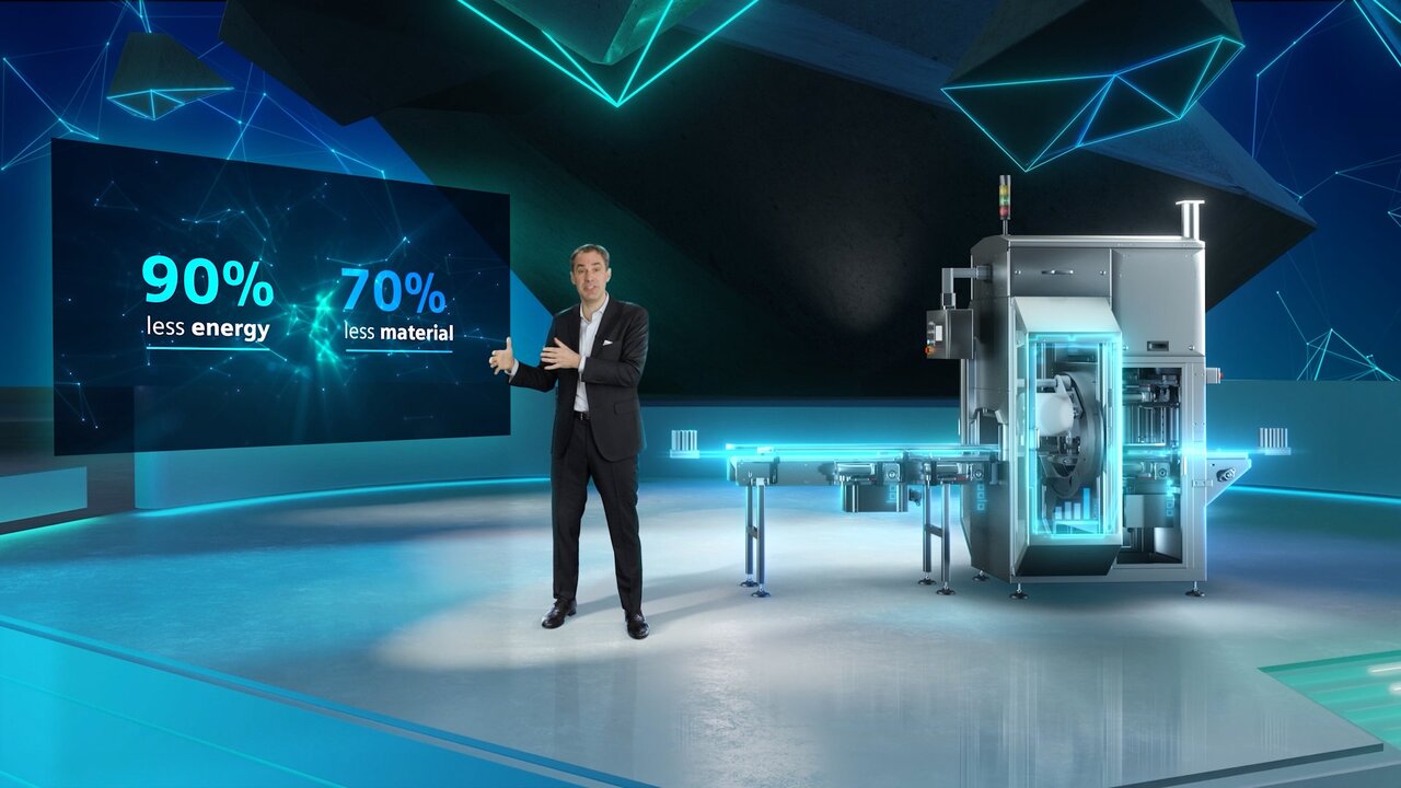 Moderator vor digitaler Verpackungsmaschine mit Infografik zu Energie- und Materialeinsparung.