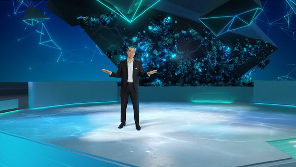 Moderator im virtuellen Studio mit leuchtendem Datennetz im Hintergrund.