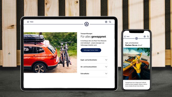 Ein Tablet und ein Smartphone zeigen die VW-Zubehörseite mit einem Auto und Fahrradträger.